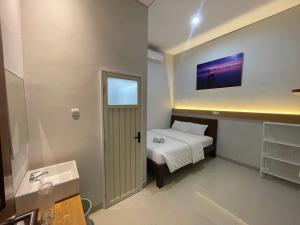 a small bathroom with a bed and a sink at Summer inn Karimunjawa in Karimunjawa