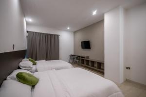 a hotel room with two beds and a flat screen tv at Altitude Loft Hotel in Maracaibo