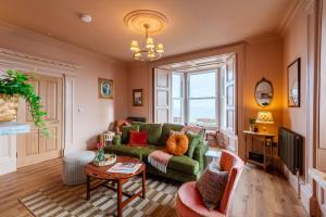 a living room with a green couch and a tv at One Roker Terrace in Monkwearmouth