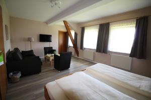 a hotel room with a bed and a couch at Hotel garni Zur Post in Utersum