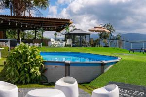a swimming pool in the middle of a yard at Glamping Renacer Vistas Turrialba, Paris in Turrialba
