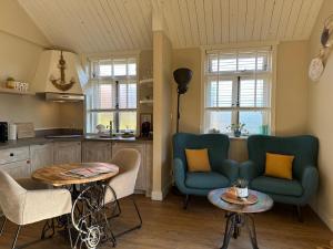 Una sala de estar con dos sillas azules y una mesa. en Beach House Texel, en De Koog