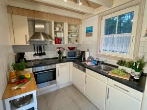 a kitchen with white cabinets and a sink at Sandrose - Baabe in Baabe