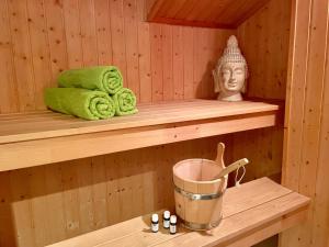 a sauna with towels and a bucket on a shelf at Sandrose - Baabe in Baabe +20 photos