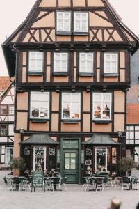 a building with tables and chairs in front of it at Denkmalsuites Quedlinburg in Quedlinburg