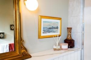 a mirror sitting on a shelf in a bathroom at One Roker Terrace in Monkwearmouth +36 photos