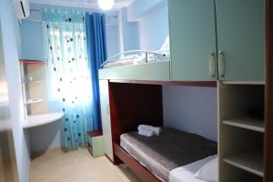 a small room with a bunk bed and blue cabinets at Apartment Rita Berat in Berat