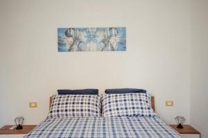 a bed with two pillows and a picture on the wall at Palazzetto San Domenico in Montesilvano