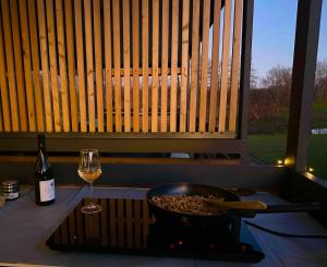 a bowl of food and a glass of wine on a counter at BREZA mobile house BIG BERRY in Metlika