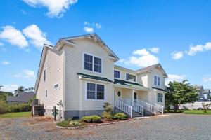 a white house with a driveway at Seas the Day - Water views, Shared pool! in Chincoteague