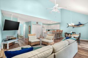 a living room with a couch and a dining room at Seas the Day - Water views, Shared pool! in Chincoteague
