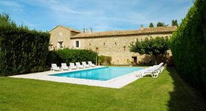 a swimming pool with lounge chairs and a building at Maison d'Hôtes Lou Geneste in Bollène +18 photos