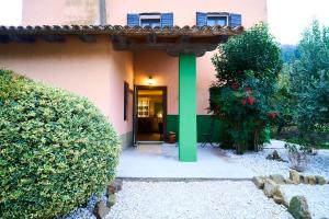 an entrance to a pink house with a green column at Locanda Borgo Colmello in Villanova di Farra +11 photos