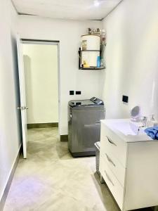 a laundry room with a sink and a washing machine at La Villa Salma in Santa Bárbara de Samaná +7 photos