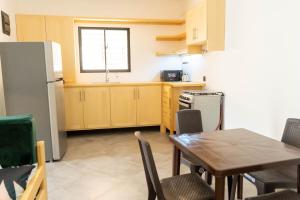 a kitchen with a table and a refrigerator at La Villa Salma in Santa Bárbara de Samaná
