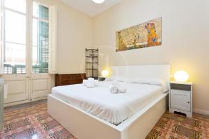une chambre avec un grand lit blanc avec un tableau sur le mur dans l'établissement Apartamento con Terraza en Poble Sec, à Barcelone
