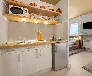 a kitchen with a sink and a microwave at Bali Room in Toulouse