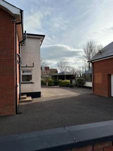 an empty parking lot next to a brick building at Farmhouse at 93 in Portglenone