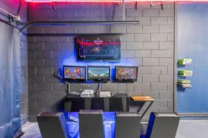 a table with chairs and a television on a wall at 7BDM Prvt Pool Villa - Gated Resort 10min to Disney in Kissimmee