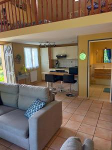 a living room with a couch and a kitchen at Gîte berneval le grand in Berneval-le-Grand