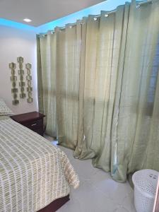 a bedroom with green curtains and a bed at Luxury Studio in San Isidro