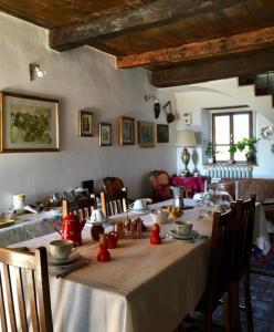 a dining room with a long table with chairs and a tableablish at La Collina Tuscan stone cottage in Soci