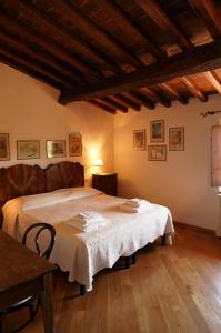 a bedroom with a bed and a wooden floor at La Collina Tuscan stone cottage in Soci