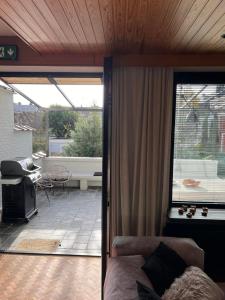 a living room with a couch and a patio at Zalig HASPENGOUW in Sint-Truiden +15 photos