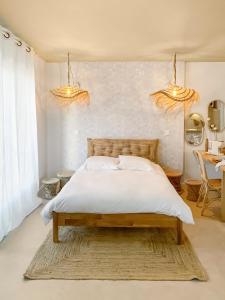 a bedroom with a bed and two chandeliers at Bali Room in Toulouse +34 photos