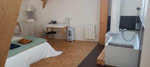 a bedroom with a bed and a desk with a television at La Métairie Du Clos Saint Louis, 4 chambres pour 8 personnes in Montréal