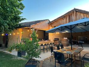 a patio with tables and chairs and a grill at La Métairie Du Clos Saint Louis, 4 chambres pour 8 personnes in Montréal