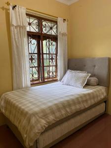 a bed in a room with a window and a bed sidx sidx sidx at 'Nanini Backyard' Home Stay in Berastagi