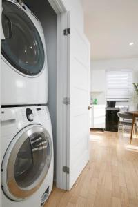 a washer and dryer in a room with a kitchen at Contemporary 2BR Retreat in MTL Village in Montréal