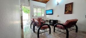 a living room with chairs and a table and a television at Casa en conjunto Flandes 3 Habitaciones in Flandes