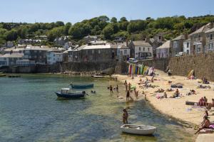 a group of people on a beach with boats in the water at 8 Millpool in Mousehole