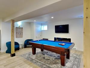 a living room with a pool table and a tv at Dacha Verde in Swanton