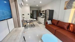 un salon avec un canapé marron et une table dans l'établissement Shi House -2BR Building S901 Cozy & Comfy Stay, à Long Bình