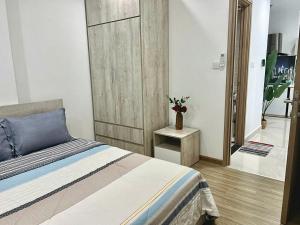 - une chambre avec un lit et un vase sur une table dans l'établissement Shi House -2BR Building S901 Cozy & Comfy Stay, à Long Bình