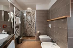 a bathroom with a shower and a toilet and a sink at Berg Hotel Latemar Spitze in Vigo di Fassa +139 photos