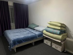 1 dormitorio con 2 camas individuales y almohadas en 2КВ-Компакт Эконом, en Karakol