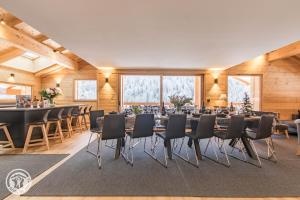 Una sala de conferencias con mesas, sillas y ventanas. en Appartement 6 chambres séjour ski, en Le Grand-Bornand