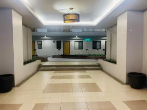 einen großen Saal mit Lobby mit Hängeleuchte in der Unterkunft Acacia Estates' The Getaway Taguig, Evergreen in Manila + 51 Fotos