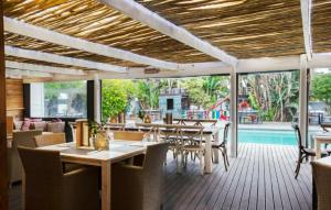 a restaurant with tables and chairs and a pool at Ibis 1 in Cape St Francis Resort in Cape St Francis