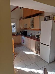 a kitchen with a white refrigerator and a tile floor at Tiny House Eurovelo 6 in Chalon-sur-Saône