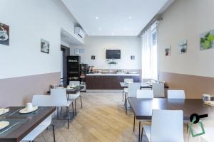 un restaurante con mesas y sillas blancas y una cocina en HOTIDAY Room Collection - Roma Barberini, en Roma