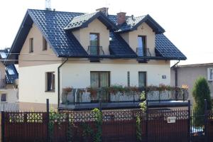 una casa blanca con techo negro y valla en Apartament Bielany Kraków en Cracovia