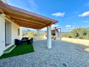 un patio con techo, mesa y sillas en Green House, en Cardedu