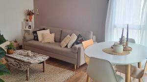 a living room with a couch and a table at Le Cocon-proche Rennes in Le Rheu