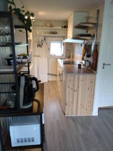 cocina con armarios blancos y suelo de madera en Arctic Retreat - two separate bedroom apartment, en Tromsø 5 fotos más