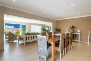 a dining room with a wooden table and chairs at Gem with indoor jacuzzi in Cape Town